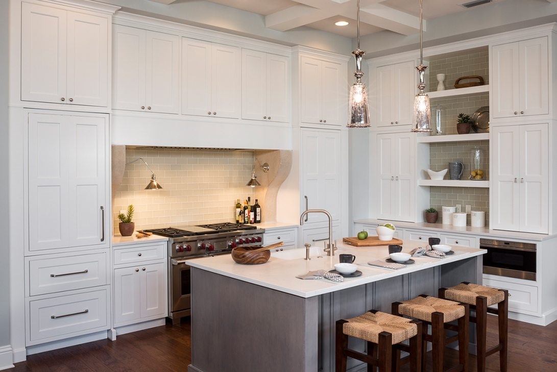 luxury kitchen with white cabinets, a gray island and exotic materials