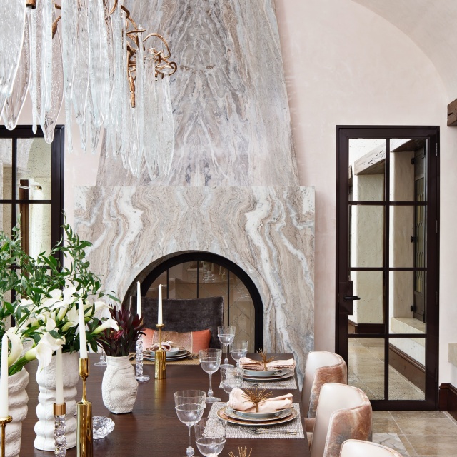 The design team preserved the dining room’s original stained glass windows. Serip lighting adds jewelry to the space, and pink side chairs from Carlyle Collective play off the hues found in the new fireplace marble. @modernluxury #featured #modernluxury #interiordesign #renovation #beforeandafter
