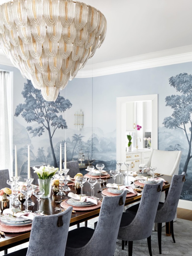 For our clients who love to host gatherings, the dining room remains among the most memorable, and used, spaces. A dreamy botanical scene, painted by muralist @mjatelier, envelops the room in a soft blue, the depicted trees seemingly asway in a breeze. A dazzling, multi-tiered 1960s Murano chandelier rises conically over the table and when turned on the light it casts onto the lacquered ceiling creates an extra shimmer and glamour to any dinner. #diningroomdesign #palmbeach #dinnerparty #interiordesign #luxuryhomes